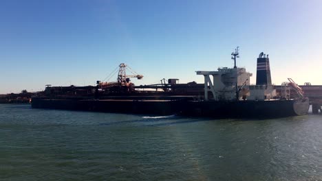 Eine-Statische-Aufnahme-Eines-Riesigen-Frachtschiffs-Mit-Riesigen-Containern-In-LKW-Größe,-Die-Auf-Tiefblauem-Meer-Kreuzen