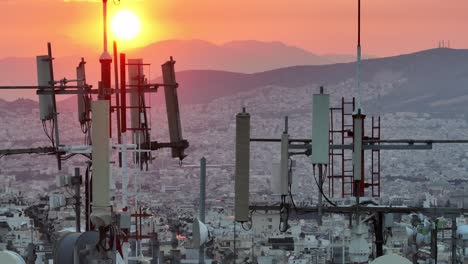 Aerial---Close-shot-of-building-antennas-with-Athens-skyline-in-the-background