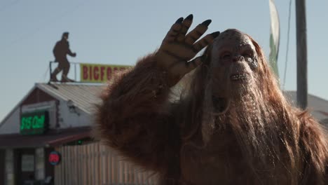 Bigfoot-Sasquatch-waving-hand-in-the-air-in-costume-walking-smiling-scary-Halloween-footage