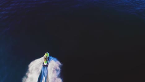 Jetski-on-the-Mediterranean-Sea,-birdseye-view-tilting-up-to-reveal-the-coastline-of-the-South-of-Spain