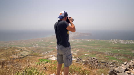 One-man-takes-pictures-on-a-hill-of-Santorini-island-in-Greece