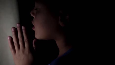 Little-boy-praying-to-God-with-hands-together-stock-footage-5