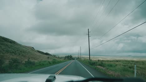 POV-driving-on-a-hawaiian-road-along-power-line-on-a-cloudy-day