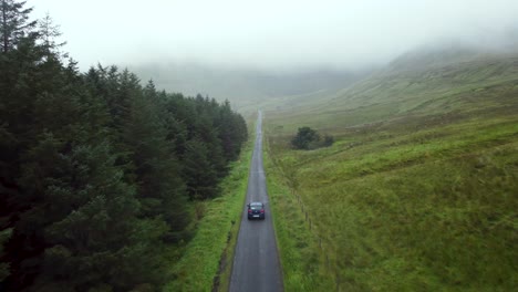 Driving-a-car-in-an-epic-road-in-the-middle-of-the-mountains-in-Ireland-in-a-fog-day