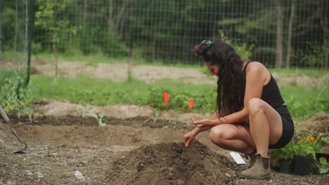 Woman-working-at-farm-in-garden-sowing-seeds