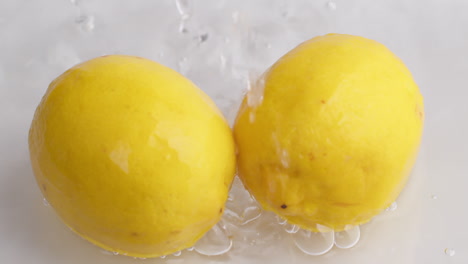 Wassertropfen-Fließen-In-Zeitlupe-Zu-Gelben-Zitronen-Hinab-1