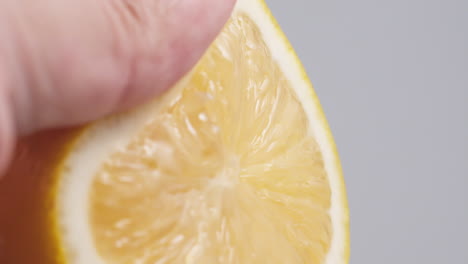 Hand-squeezes-fresh-natural-juice-out-of-the-lemon