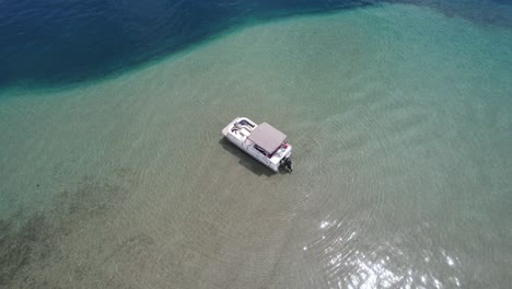 A-pontoon-boat-is-anchored-on-the-edge-of-the-drop-off-at-Detroit-Point-on-Higgins-Lake,-Roscommon,-MI-5