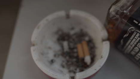 Cigarette-end-in-ashtray,-Handheld,-Closeup