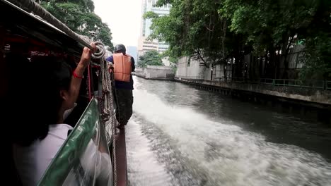 Man-riding-on-the-side-of-a-water-taxi