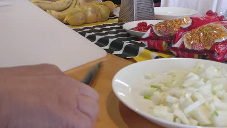 High-speed-time-lapse-of-person-slicing-onions-on-cutting-board-preparing-delicious-meal-in-kitchen