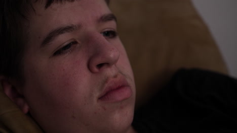 Closeup-of-a-sad,-troubled,-serious,-contemplative-young-man,-teenager-watching-tv