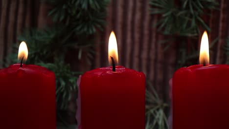 Red-Christmas-candle-light-burning-against-wooden-background