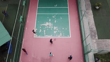 Drone-footage-of-some-people-playing-tennis-in-an-old-playground-against-the-wall-called-fronton