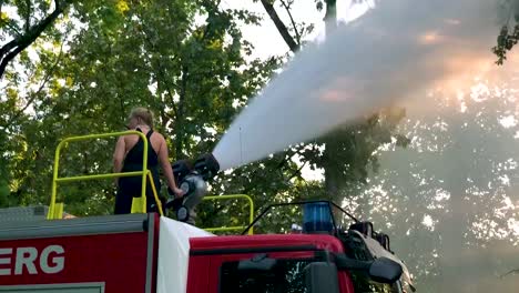 Deutsches-Feuerwehrauto,-Das-An-Einem-Heißen-Sommertag-Wasser-Für-Kinder-Und-Bäume-Sprüht-14
