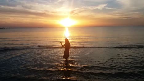 Silhouette-Der-Jungen-Dame-Am-Strand-Bei-Sonnenuntergang