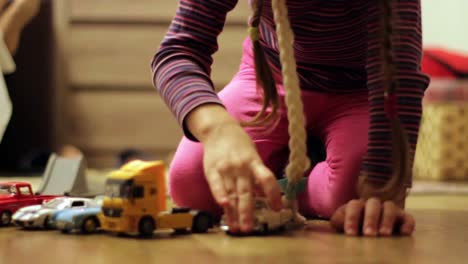 Child-Girl-Plays-With-a-Small-Toy-Cars
