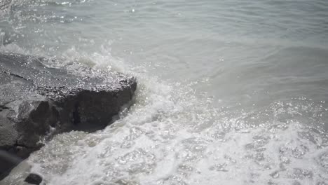Waves-crashing-on-rock-and-washing-the-sand