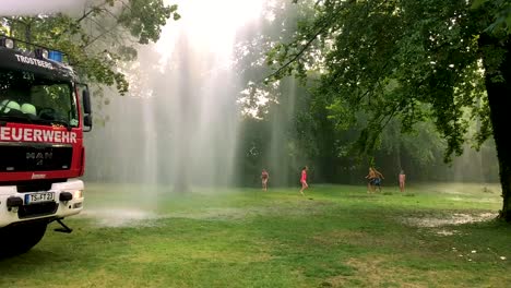 German-firetruck-spraying-water-for-kids-and-trees-on-a-hot-summer-day-5