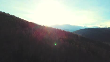 Drone-flying-over-the-mountains-to-the-sun