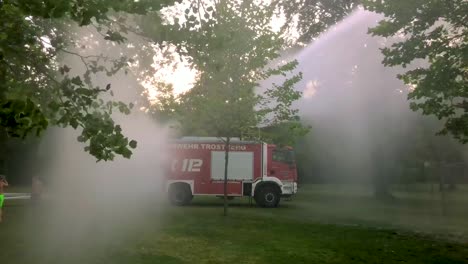 German-firetruck-spraying-water-for-kids-and-trees-on-a-hot-summer-day-2