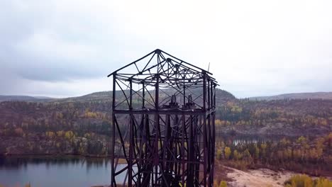 Slow-motion-Aerial-Orbit-Panning-shot-of-an-abandoned-mine-headframe-in-the-boreal-forest-in-the-fall