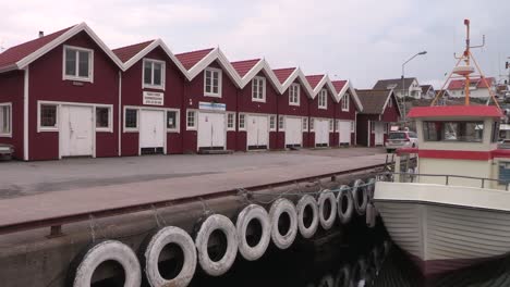 Pan-shot-in-harbour-of-Smoegen-with-fishing-cutter-and-storehouses,-Sweden