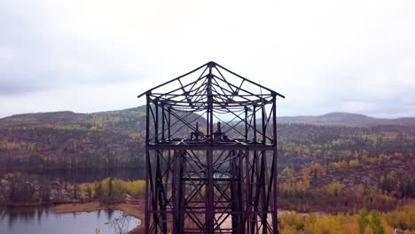 Aerial-Orbit-Panning-shot-of-an-abandoned-mine-headframe-in-the-boreal-forest-in-the-fall