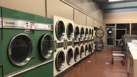 4k-UHD-handheld-footage-of-a-clean,-brightly-lit,-empty-Laundromat-shot-from-outside-at-night