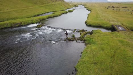 Luftvideo-Eines-Mannes,-Der-Im-Fossalar-Fluss-In-Island-Nach-Lachs-Fischt