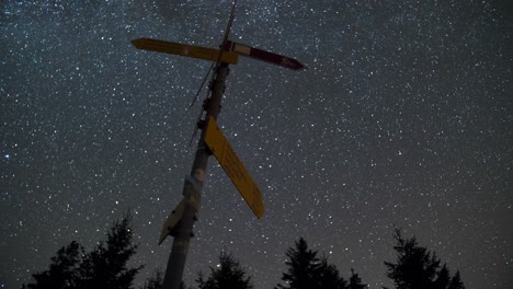 Zoom-out-timelapse-of-the-nightsky-with-a-signpost