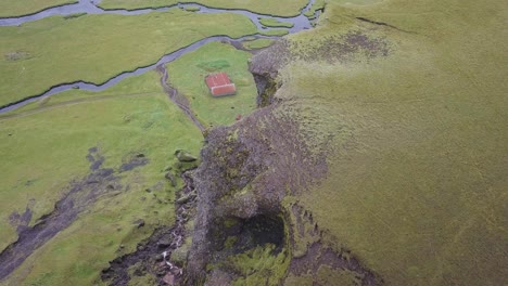 Aerial-video-fliyng-over-a-mountain-revealinga-barn-and-a-river