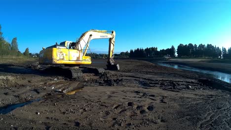 Yellow-Excavator-Works-with-Bucket-to-Clear-Mud-Sludge-and-Debris-from-the-bottom-of-the-Drained-River-1