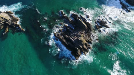 Waves-crashing-up-against-rocks-against-the-coast-near-Byron-Bay,-Australia