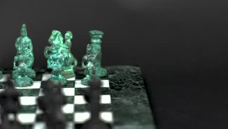 Ancient-marble-chessboard-with-teal-bronce-knights-as-pawns-slider-macro-1