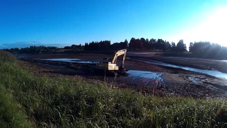 Yellow-Excavator-Works-with-Bucket-to-Clear-Mud-Sludge-and-Debris-from-the-bottom-of-the-Drained-River-3