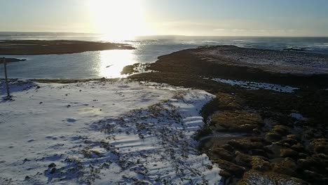 Aerial-shot-pulling-away-from-Keflavik-coast-in-Winter-at-sunset