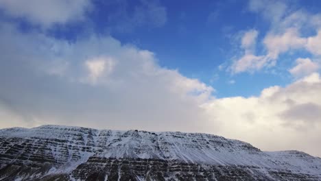 Steadi-Cam-Shot-Conduciendo-Más-Allá-De-Una-Gran-Montaña-Cubierta-De-Nieve-En-Islandia-En-Invierno
