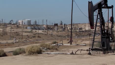 Oil-field-with-oil-pump-with-oil-pumps-and-tanks-in-California,-USA