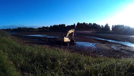 Yellow-Excavator-Works-with-Bucket-to-Clear-Mud-Sludge-and-Debris-from-the-bottom-of-the-Drained-River-2