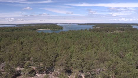 Pan-shot-of-coniferous-forest-in-Finland-from-above-with-lake-and-archipelagos