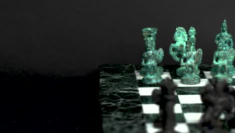 Ancient-marble-chessboard-with-teal-bronce-knights-as-pawns-slider-macro