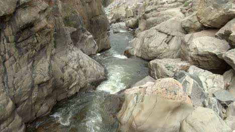 Aerial-dolly-over-river-downstream-in-canyon-in-Colorado