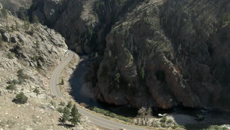 Aerial-over-empty-road-in-canyon-next-to-river-in-Colorado
