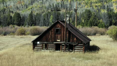 Dolly-zoom-of-cabin-in-field-with-mountains-in-background