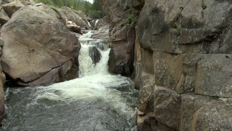 Aerial-slow-rise-of-small-waterfall-in-canyon-in-Colorado