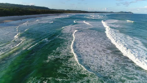 Fliegen-Sie-Tief-über-Einen-Atemberaubenden-Strand-Mit-Sich-Wiederholenden-Wellen,-Die-Gegen-Den-Strand-Schlagen