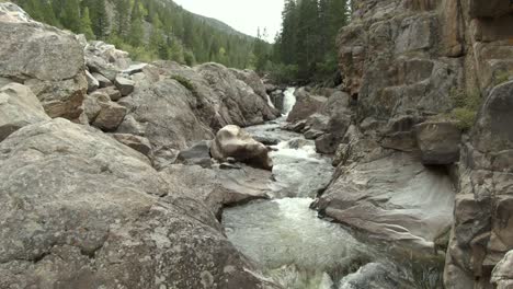 Aerial-dolly-over-river-with-small-waterfalls-in-canyon-in-Colorado