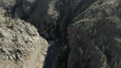 Aerial-over-road-in-canyon-next-to-river-with-cars-in-Colorado