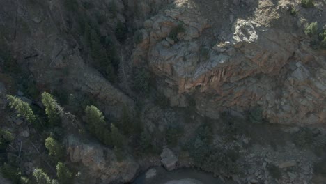 Aerial-pan-up-of-road,-river-and-rock-in-canyon-in-Colorado